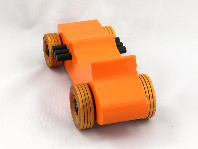 Handmade wooden toy car modeled after a 1927 T-Bucket hot rod. Finished with orange and black acrylic paint and amber shellac.