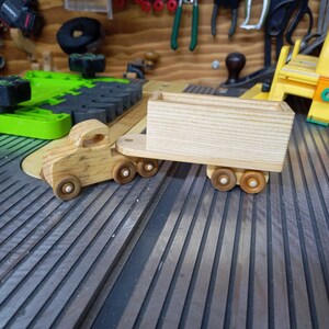 Handmade wooden toy tractor trailer semi truck finished with clear shellac. Crafted from natural wood using traditional woodworking tools. Approximate size 7 inches long. Made in Tallahassee, Florida, USA from Odin's Toy Factory Play Pal Collection.