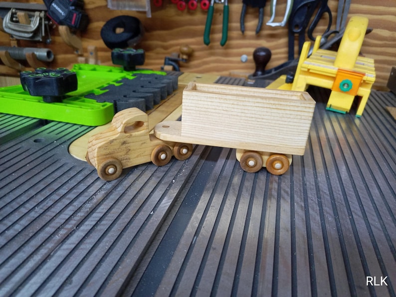 Handmade wooden toy tractor trailer semi truck finished with clear shellac. Crafted from natural wood using traditional woodworking tools. Approximate size 7 inches long. Made in Tallahassee, Florida, USA from Odin's Toy Factory Play Pal Collection.