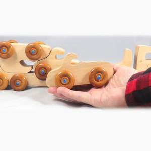 Handmade wooden toy truck play set includes three cars and a tractor-trailer finished with clear and amber shellac with metallic sapphire blue trim.