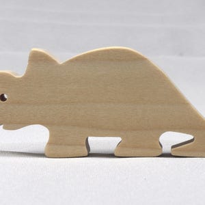 This is an unfinished wooden Wooden Toy Dinosaur Triceratops cutout from solid wood using traditional woodworking techniques. Sanded smooth and ready to paint, stain, or customize. Freestanding design for small hands, toddlers, young children, crafters, collectors, and display. I take custom orders for any animal, quantity, and mix — including large ornament orders. Mix and match, request a different size, or send a drawing or pattern. Handmade by Odin's Toy Factory in Tallahassee, Florida, USA.