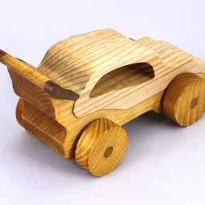 Handmade wooden toy car finished with nontoxic clear amber shellac and contrasting wood trim. Part of the Speedy Wheels Collection. Handcrafted in Tallahassee, Florida, USA. Length 5-1/2 inches, width 2-1/2 inches, height 2-1/2 inches. Made at Odin's Toy Factory.