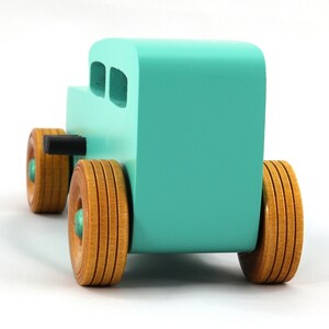 Handmade wooden toy car, 1932 Hot Rod Sedan, painted turquoise with metallic green and black trim. The wheels are finished with nonmarring amber shellac. Handcrafted from natural wood in Tallahassee, Florida, USA. Approximate size: 6 inches long, 3 inches high, 2.5 inches wide. Odin's Toy Factory custom wooden toy.