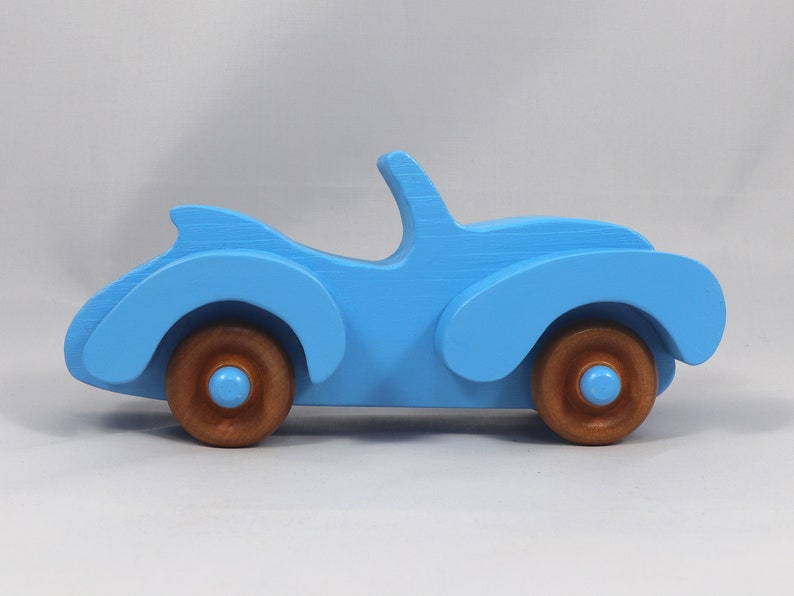 Handmade painted wooden toy car, baby blue convertible with fat fendered roadster design. Non-marring wheels finished with amber shellac.
