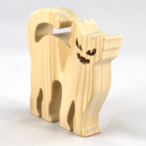 Handmade unfinished wooden Halloween cat cutout by Odin's Toy Factory. Freestanding cat figure cut from 3/4 inch thick wood and ready to paint. Approximate size 3.5 inches height by 3.5 inches width by 0.75 inches thick. Hand-cut solid wood Halloween decoration for crafts, toys, ornaments, and display. Custom orders available. Made in Tallahassee, Florida, USA.