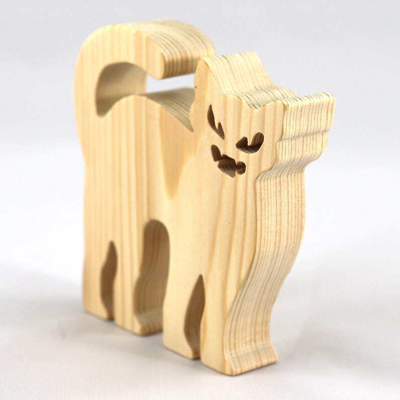 Handmade unfinished wooden Halloween cat cutout by Odin's Toy Factory. Freestanding cat figure cut from 3/4 inch thick wood and ready to paint. Approximate size 3.5 inches height by 3.5 inches width by 0.75 inches thick. Hand-cut solid wood Halloween decoration for crafts, toys, ornaments, and display. Custom orders available. Made in Tallahassee, Florida, USA.