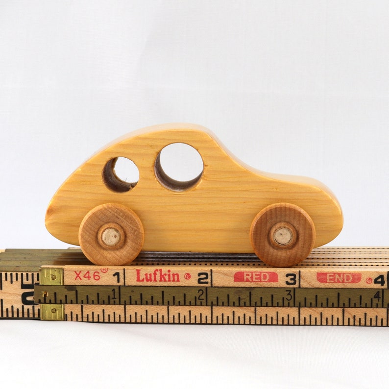 A handmade wooden toy car from the My Play Pal collection finished with durable satin polyurethane and amber shellac. It is made to order.