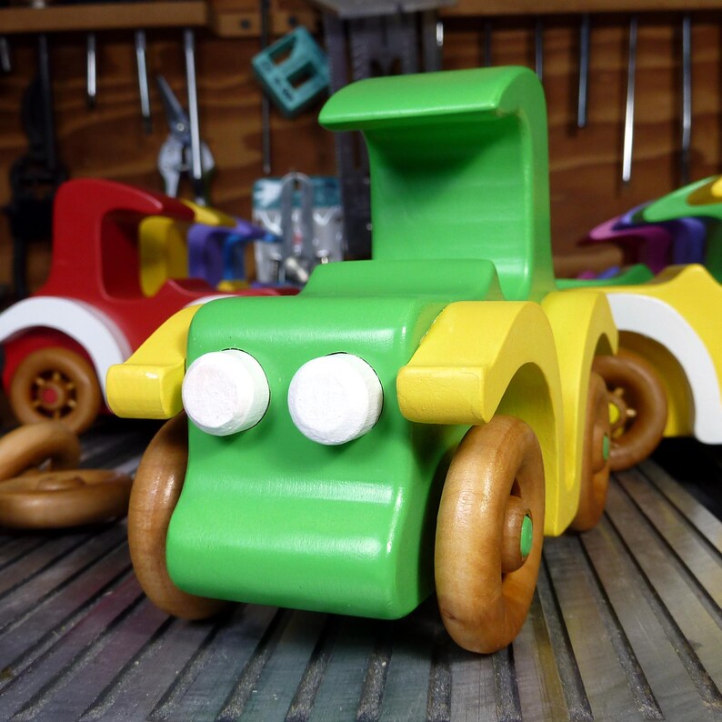 Handmade wooden toy car, vintage-style Model T sedan, painted bright green and yellow with spoked wheels, finished in amber shellac.  Handcrafted in Tallahassee, Florida, USA by Odin's Toy Factory.
