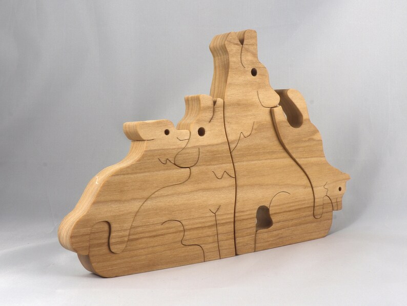 Wooden Wolf Family Stacking Puzzle is handmade from hardwood and finished with mineral oil, beeswax, and carnauba wax. Freestanding interlocking wolf family puzzle pieces shown assembled. Approximate size 10.5 inches long by 6.7 inches high by 3/4 inch thick. Handmade in Tallahassee, Florida, USA.