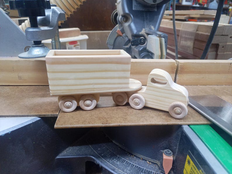 Handmade wooden toy tractor trailer semi truck finished with clear shellac. Crafted from natural wood using traditional woodworking tools. Approximate size 7 inches long. Made in Tallahassee, Florida, USA from Odin's Toy Factory Play Pal Collection.