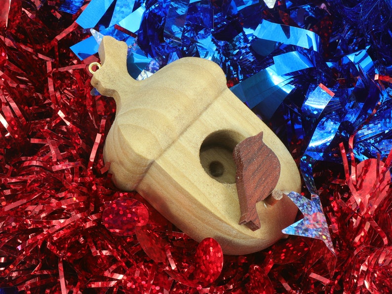 Handmade wooden miniature birdhouse ornament cut from wood with rounded edges, natural wood grain and color variations, finished with non-toxic shellac or food-safe oils and beeswax, lightweight and ready to hang. Made in Tallahassee, Florida, USA, by Odin's Toy Factory.