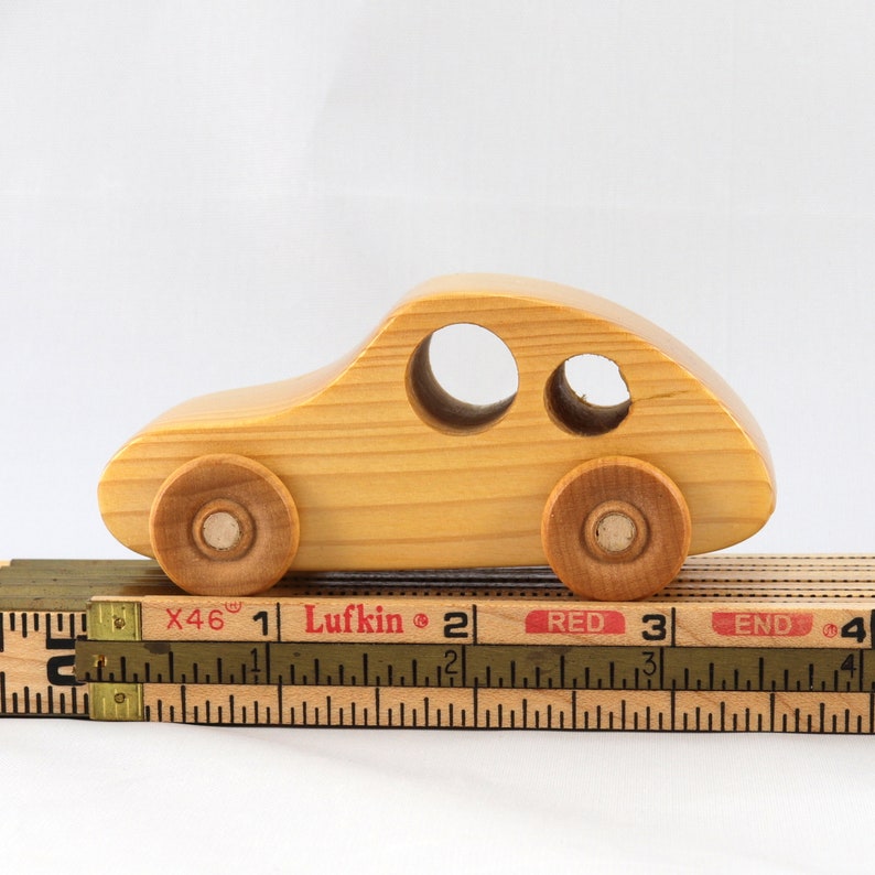 A handmade wooden toy car from the My Play Pal collection finished with durable satin polyurethane and amber shellac. It is made to order.