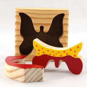 A wooden three-piece butterfly tray puzzle, handmade and finished. The butterfly is painted bright red and yellow with orange spots. The wooden tray is finished with clear shellac. It is one of four puzzles in my Puzzle Pals Collection.