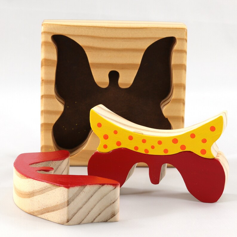 A wooden three-piece butterfly tray puzzle, handmade and finished. The butterfly is painted bright red and yellow with orange spots. The wooden tray is finished with clear shellac. It is one of four puzzles in my Puzzle Pals Collection.