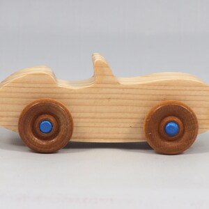 Handmade wooden toy car convertible sports coupe with a nontoxic satin polyethylene finish, amber shellac wheels, and metallic sapphire blue trim.