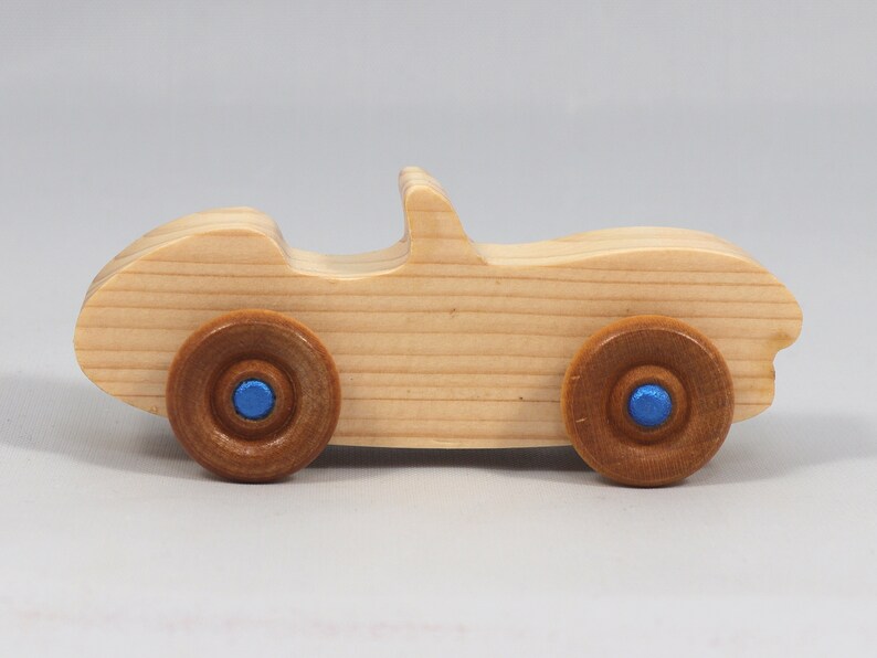 Handmade wooden toy car convertible sports coupe with a nontoxic satin polyethylene finish, amber shellac wheels, and metallic sapphire blue trim.