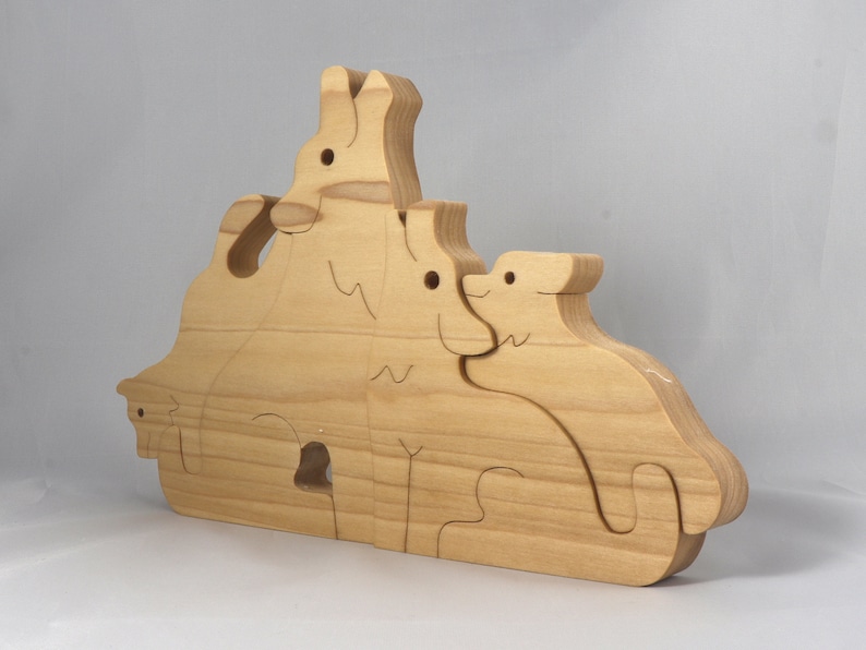 Wooden Wolf Family Stacking Puzzle is handmade from hardwood and finished with mineral oil, beeswax, and carnauba wax. Freestanding interlocking wolf family puzzle pieces shown assembled. Approximate size 10.5 inches long by 6.7 inches high by 3/4 inch thick. Handmade in Tallahassee, Florida, USA.