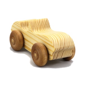 A small, handcrafted wooden toy convertible sports car, finished with a custom blend of oils and waxes, is the perfect gift for young children.