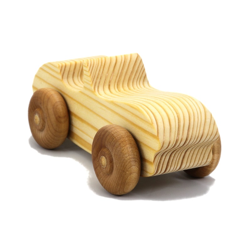 A small, handcrafted wooden toy convertible sports car, finished with a custom blend of oils and waxes, is the perfect gift for young children.