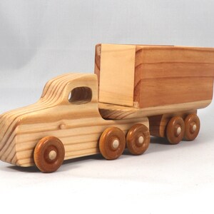 Handmade wooden toy tractor trailer semi truck finished with clear shellac. Crafted from natural wood using traditional woodworking tools. Approximate size 7 inches long. Made in Tallahassee, Florida, USA from Odin's Toy Factory Play Pal Collection.