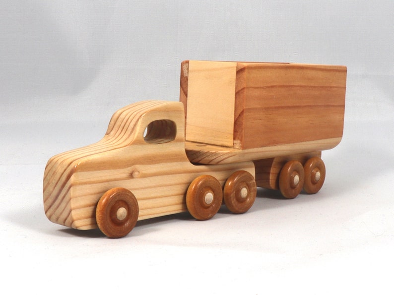 Handmade wooden toy tractor trailer semi truck finished with clear shellac. Crafted from natural wood using traditional woodworking tools. Approximate size 7 inches long. Made in Tallahassee, Florida, USA from Odin's Toy Factory Play Pal Collection.
