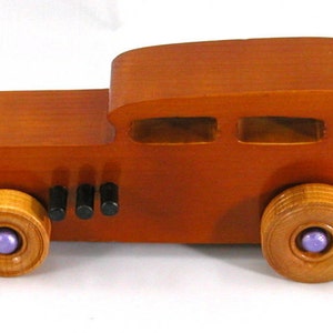 This is a handmade wooden toy car modeled after a Hot Rod 1932 Ford Sedan. It is made from wood, finished with multiple coats of amber shellac, and trimmed with black and metallic purple acrylic paint.