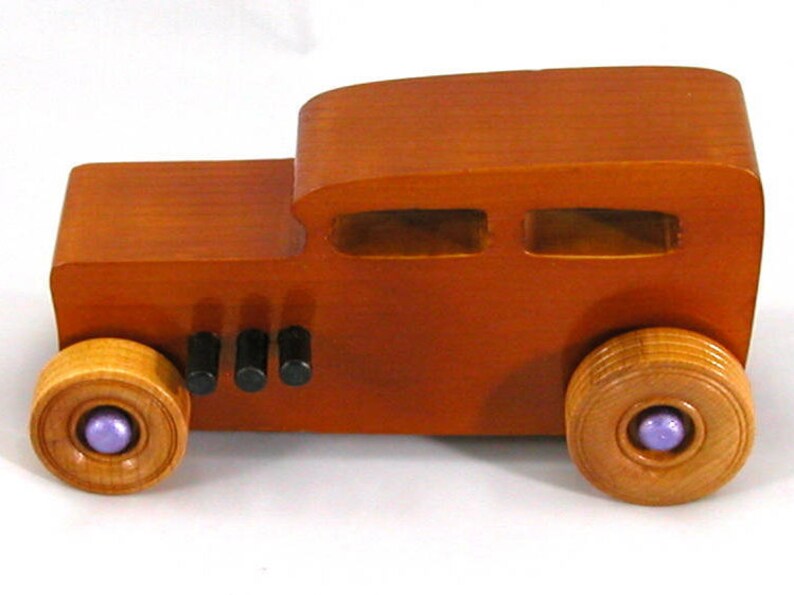 This is a handmade wooden toy car modeled after a Hot Rod 1932 Ford Sedan. It is made from wood, finished with multiple coats of amber shellac, and trimmed with black and metallic purple acrylic paint.