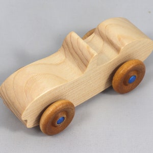 Handmade wooden toy car convertible sports coupe with a nontoxic satin polyethylene finish, amber shellac wheels, and metallic sapphire blue trim.