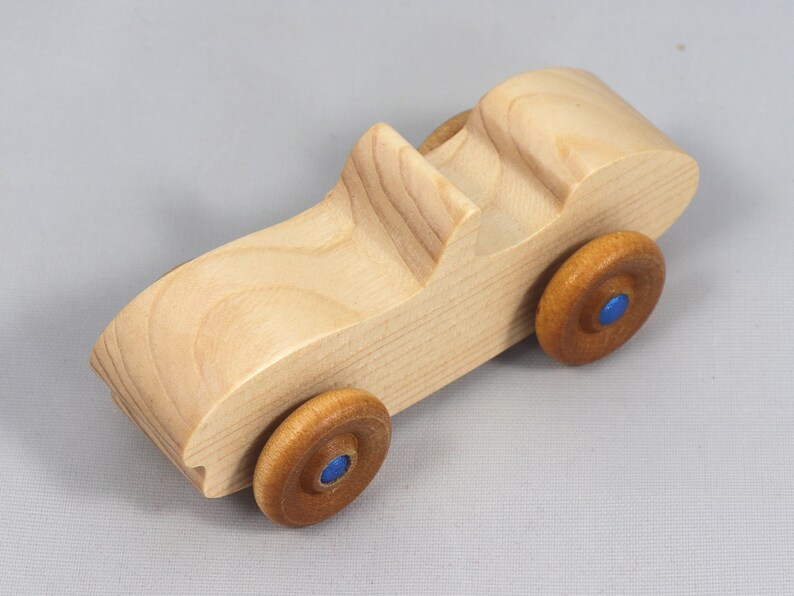 Handmade wooden toy car convertible sports coupe with a nontoxic satin polyethylene finish, amber shellac wheels, and metallic sapphire blue trim.