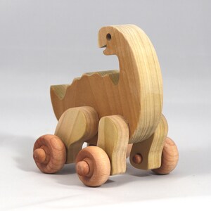Handmade wooden push toy dinosaur made from select grade hardwoods and finished with a non-toxic coating.
