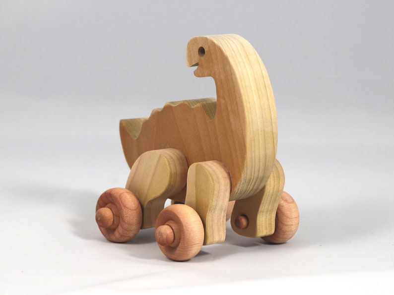 Handmade wooden push toy dinosaur made from select grade hardwoods and finished with a non-toxic coating.