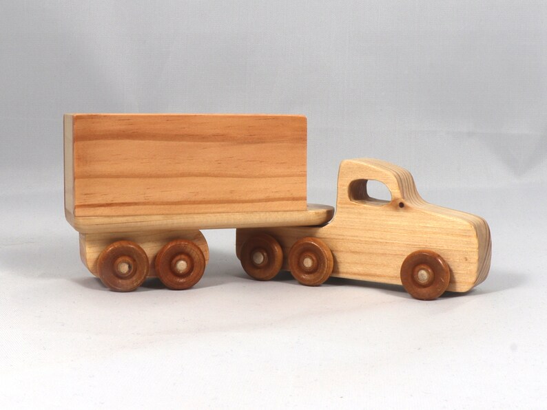 Handmade wooden toy tractor trailer semi truck finished with clear shellac. Crafted from natural wood using traditional woodworking tools. Approximate size 7 inches long. Made in Tallahassee, Florida, USA from Odin's Toy Factory Play Pal Collection.