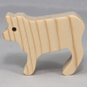 This is an unfinished wooden Calf cutout from solid wood using traditional woodworking techniques. Sanded smooth and ready to paint, stain, or customize. Freestanding design for small hands, toddlers, young children, crafters, collectors, and display. I take custom orders for any animal, quantity, and mix — including large ornament orders. Mix and match, request a different size, or send a drawing or pattern. Handmade by Odin's Toy Factory in Tallahassee, Florida, USA.