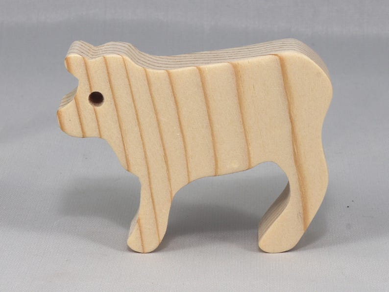 This is an unfinished wooden Calf cutout from solid wood using traditional woodworking techniques. Sanded smooth and ready to paint, stain, or customize. Freestanding design for small hands, toddlers, young children, crafters, collectors, and display. I take custom orders for any animal, quantity, and mix — including large ornament orders. Mix and match, request a different size, or send a drawing or pattern. Handmade by Odin's Toy Factory in Tallahassee, Florida, USA.