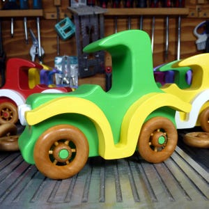 Handmade wooden toy car, vintage-style Model T sedan, painted bright green and yellow with spoked wheels, finished in amber shellac.  Handcrafted in Tallahassee, Florida, USA by Odin's Toy Factory.