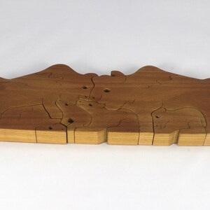 Wooden 6-piece bison family puzzle with two adult bison and four calves. The hardwood pieces interlock into one standing group or separate to stand alone. Handnmade in Tallahassee, Florida, USA by Odin's Toy Factory.