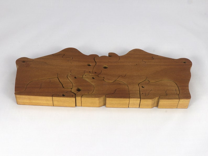 Wooden 6-piece bison family puzzle with two adult bison and four calves. The hardwood pieces interlock into one standing group or separate to stand alone. Handnmade in Tallahassee, Florida, USA by Odin's Toy Factory.