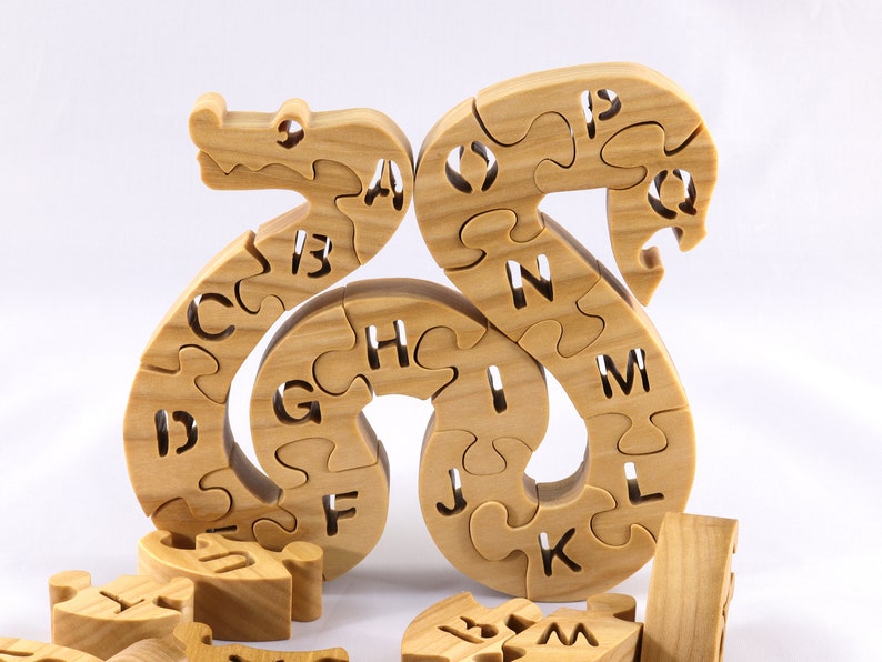 Hand-cut Alphabet Snake Puzzle made from premium hardwood, finished with mineral oil and beeswax for durability. Each of the 26 pieces represents a letter, promoting alphabet learning and essential skills development in kids through play.