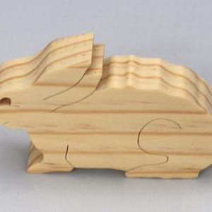 This is an unfinished wooden Rabbit cutout from solid wood using traditional woodworking techniques. Sanded smooth and ready to paint, stain, or customize. Freestanding design for small hands, toddlers, young children, crafters, collectors, and display. I take custom orders for any animal, quantity, and mix — including large ornament orders. Mix and match, request a different size, or send a drawing or pattern. Handmade by Odin's Toy Factory in Tallahassee, Florida, USA.