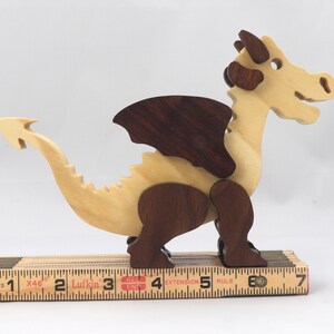 Wood Dragon Fantasy Animal Figurine is Handmade and finished with a renewable blend of mineral oil and waxes Applied hot for durabiliity and to enhance the beauty of the wood. There are ten dragons in this collection. A  link is in the description.