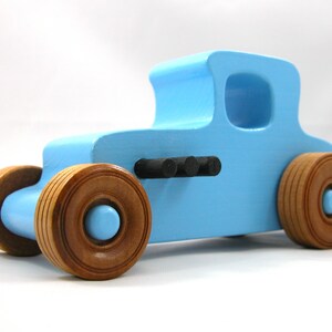 Handmade wooden toy car modeled after a '27 T-Coupe, finished with baby blue and black acrylic paint with nonmarring amber shellac wheels from my hot rod collection.