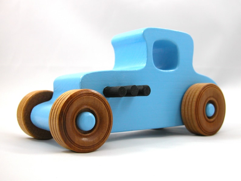 Handmade wooden toy car modeled after a '27 T-Coupe, finished with baby blue and black acrylic paint with nonmarring amber shellac wheels from my hot rod collection.