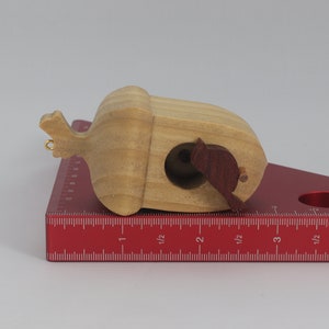 Handmade wooden miniature birdhouse ornament cut from wood with rounded edges, natural wood grain and color variations, finished with non-toxic shellac or food-safe oils and beeswax, lightweight and ready to hang. Made in Tallahassee, Florida, USA, by Odin's Toy Factory.