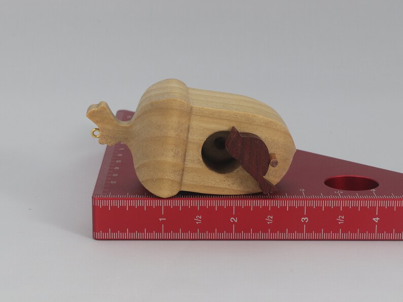 Handmade wooden miniature birdhouse ornament cut from wood with rounded edges, natural wood grain and color variations, finished with non-toxic shellac or food-safe oils and beeswax, lightweight and ready to hang. Made in Tallahassee, Florida, USA, by Odin's Toy Factory.