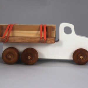 Handmade wooden toy lumber truck from Odin's Toy Factory Easy 5 Truck Fleet Collection. Painted lumber truck with acrylic body, shellac bed, and wheels. Measures approximately 9 inches long, 4 inches high, and 3.5 inches wide. Handmade in Tallahassee, Florida, USA. Custom colors available.