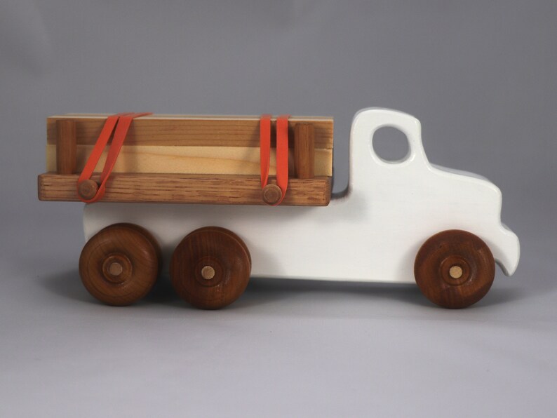 Handmade wooden toy lumber truck from Odin's Toy Factory Easy 5 Truck Fleet Collection. Painted lumber truck with acrylic body, shellac bed, and wheels. Measures approximately 9 inches long, 4 inches high, and 3.5 inches wide. Handmade in Tallahassee, Florida, USA. Custom colors available.