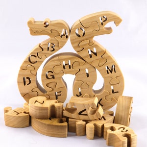 Hand-cut Alphabet Snake Puzzle made from premium hardwood, finished with mineral oil and beeswax for durability. Each of the 26 pieces represents a letter, promoting alphabet learning and essential skills development in kids through play.