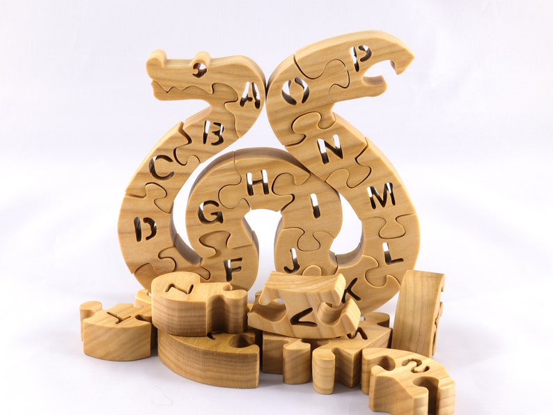 Hand-cut Alphabet Snake Puzzle made from premium hardwood, finished with mineral oil and beeswax for durability. Each of the 26 pieces represents a letter, promoting alphabet learning and essential skills development in kids through play.