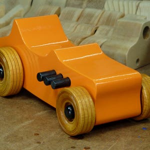 Handmade wooden toy car modeled after a 1927 T-Bucket hot rod. Finished with orange and black acrylic paint and amber shellac.