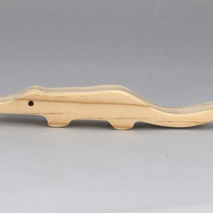 Handmade toy alligator cutout from the Itty Bitty Animal Collection. Crafted with traditional woodworking tools, this unfinished wood alligator is freestanding, smooth-sanded, and ready to paint. Perfect for stacking and imaginative play.